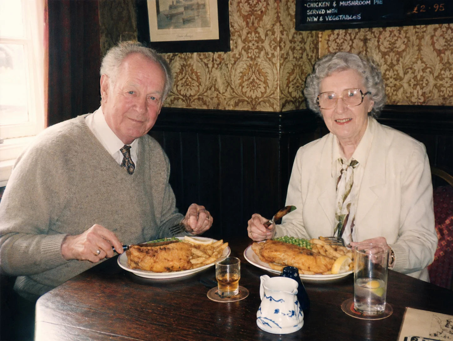Foto candida amatoriale di una coppia anziana seduta in tradizionale pub Yorkshire con fish and chips